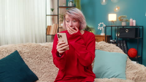 young woman celebrating victory in online mobile game expressing excited surprise joyful emotions