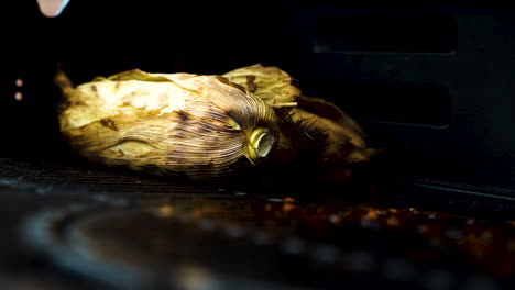 Toma-En-Cámara-Lenta-De-La-Tapa-De-La-Barbacoa-Que-Se-Cierra-Para-Mantener-El-Calor-Contenido-Encerrando-Un-Poco-De-Maíz