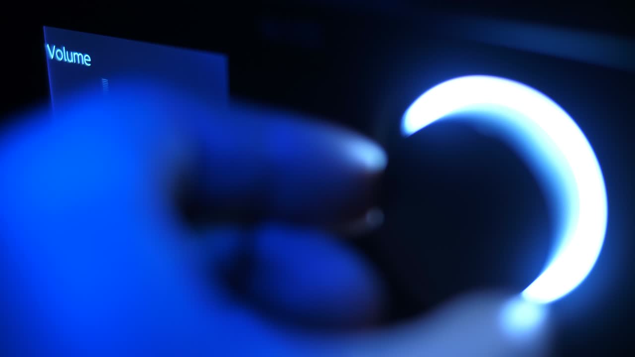 어 속에서 손은 볼 컨트롤을 돌리고, 파란 빛으로 조명됩니다.