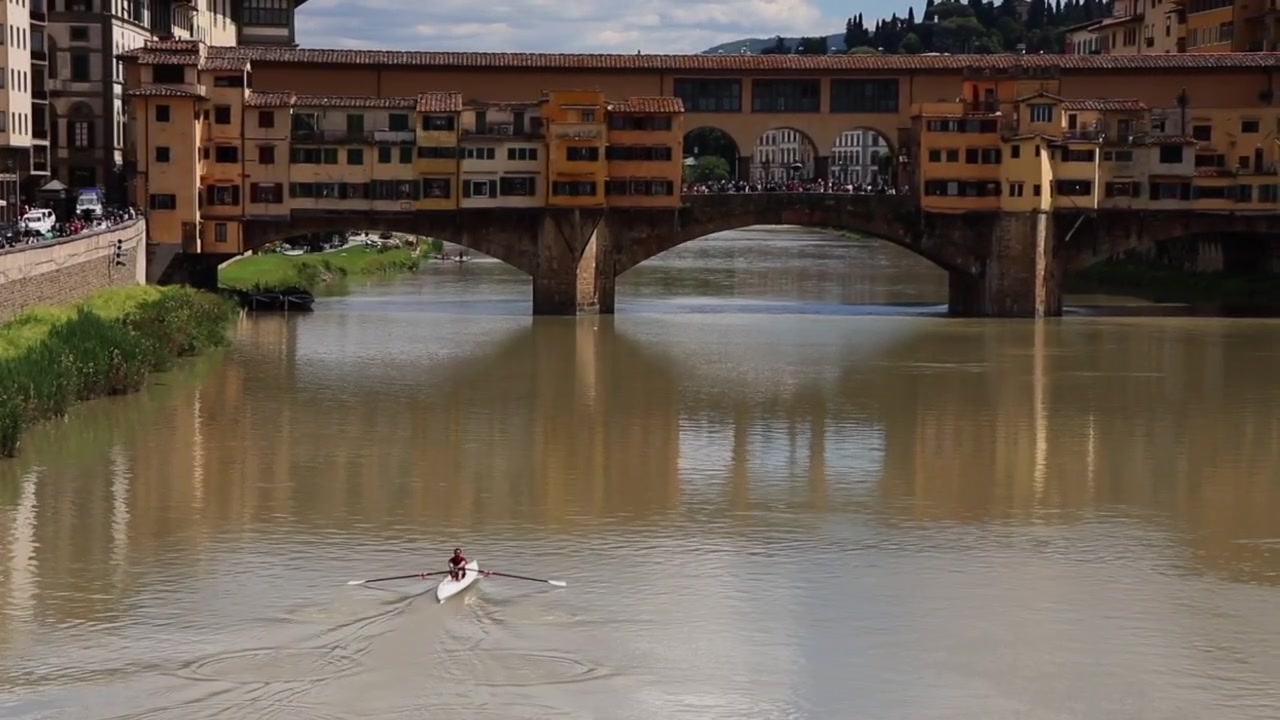 Uomo che rema in kayak lungo un canale a Firenze, Italia