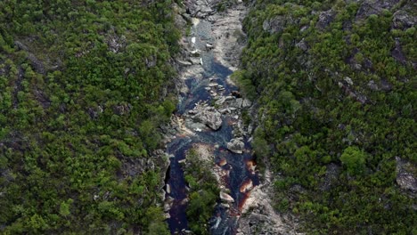 aerial drone top-down passing shot above an incredibly stunning rocky and windy river leading to the devil's pit on a hike in the beautiful chapada diamantina national park in northeastern brazil