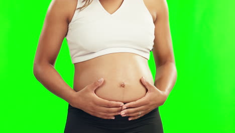 Hands,-pregnant-and-stomach-of-a-woman-on-a-green