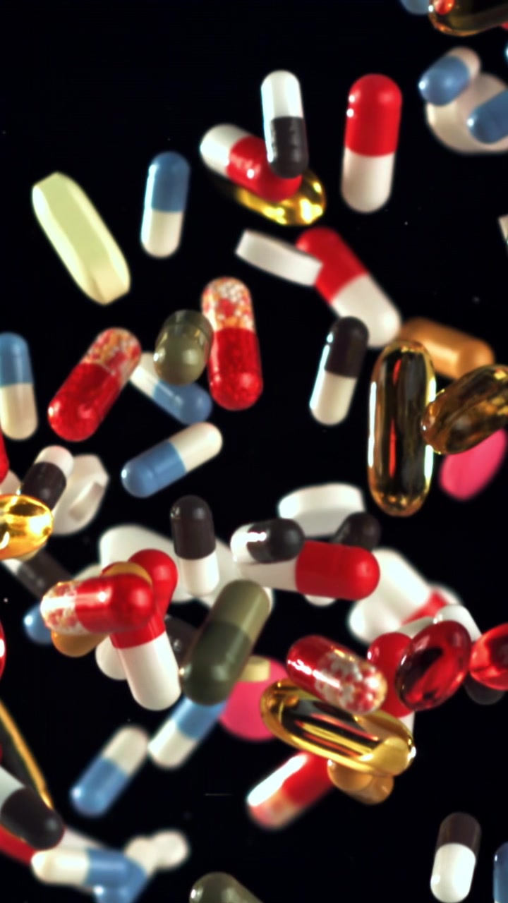 Colorful Pills and Capsules Falling in Slow Motion