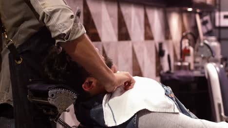 barbero masculino poniendo una toalla en el cuello del cliente