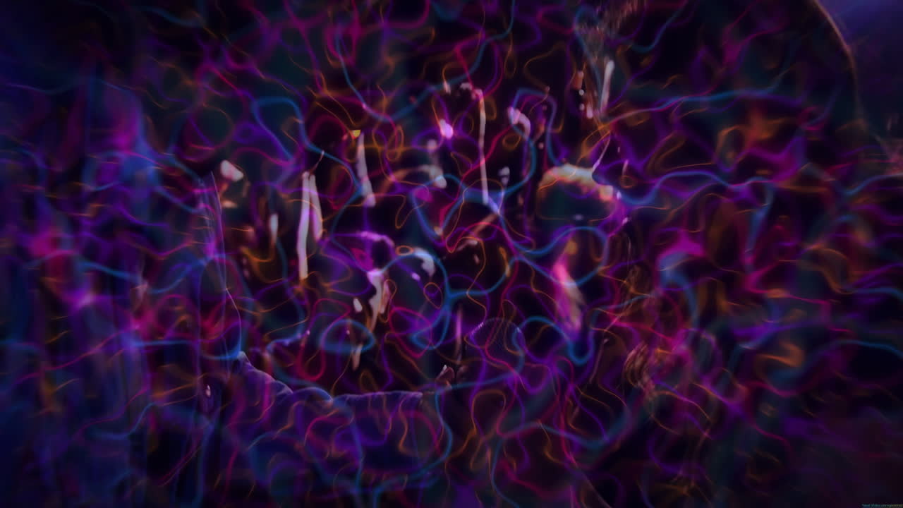 Siluety mužů a žen tančící uprostřed neonových světelných stop, vytvářející psychedelickou klubovou zábavu.