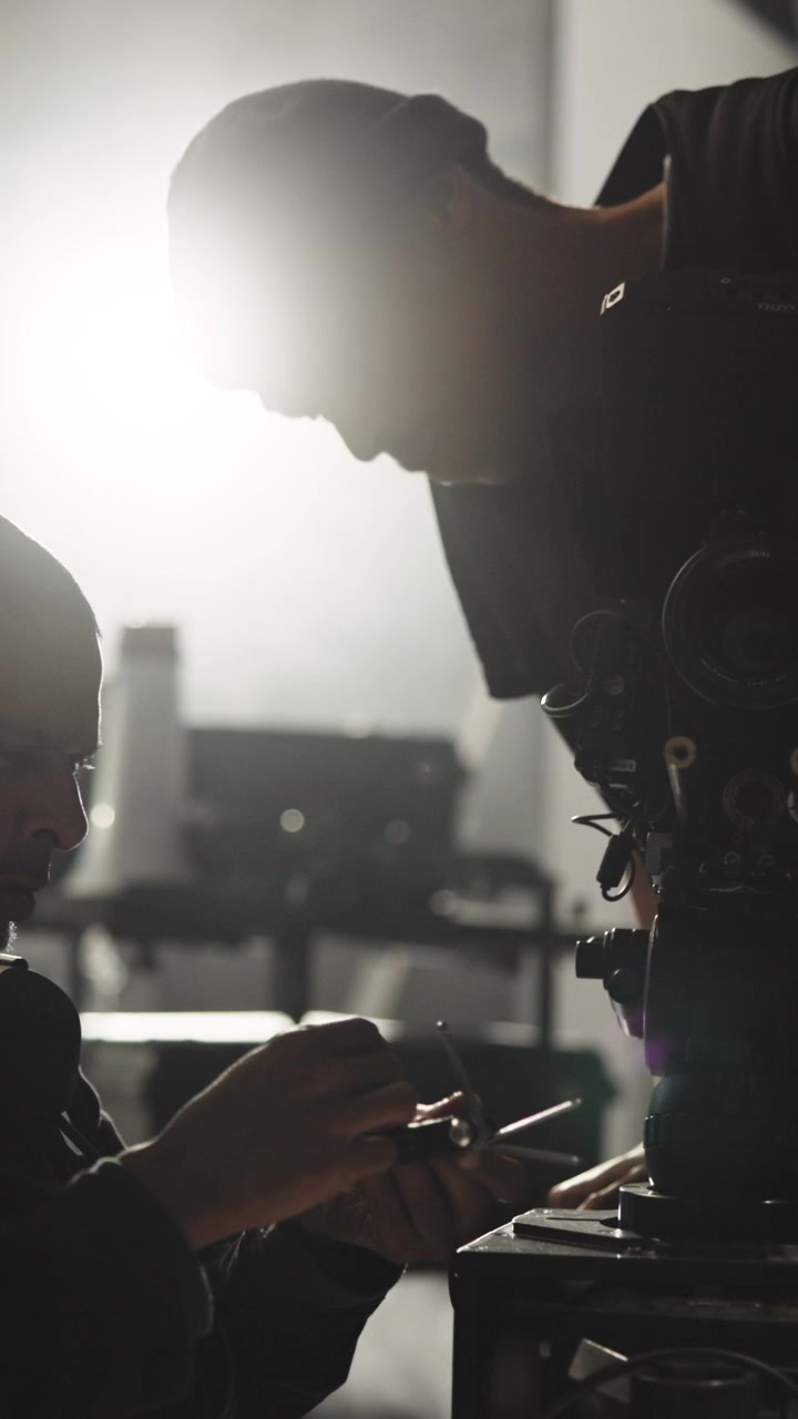 Film Crew Members Adjusting Professional Cinema Camera on Set