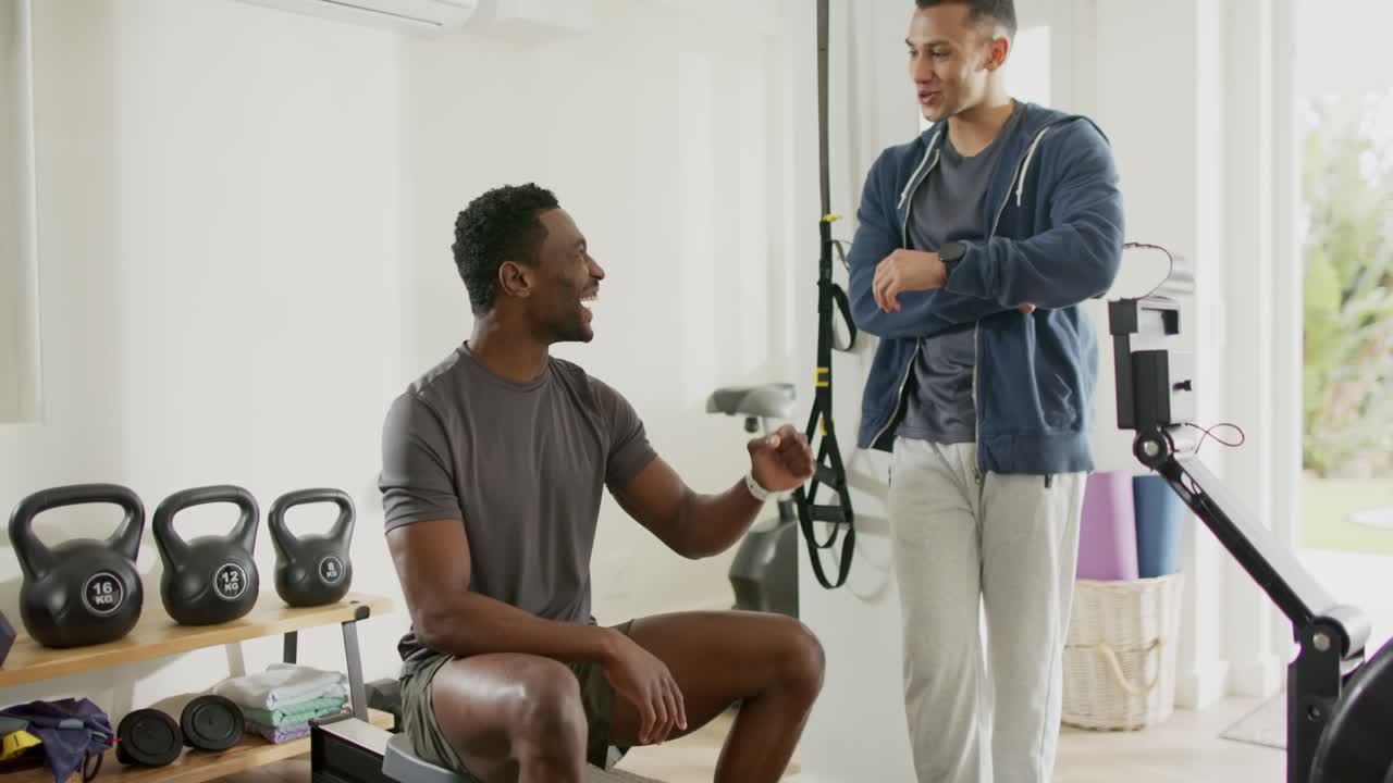 Personal Trainer und KundIn überprüfen die Smartwatch-Werte, während der/die TrainerIn das Armband auf der Gymnastikbank anpasst