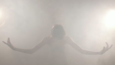 cheerful elegant japanese girl performing ballet in the smoke