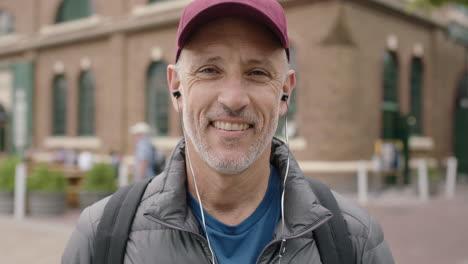 retrato de un hombre caucásico maduro y atractivo sonriendo alegremente con auriculares escuchando música bailando disfrutando de unas vacaciones de viaje