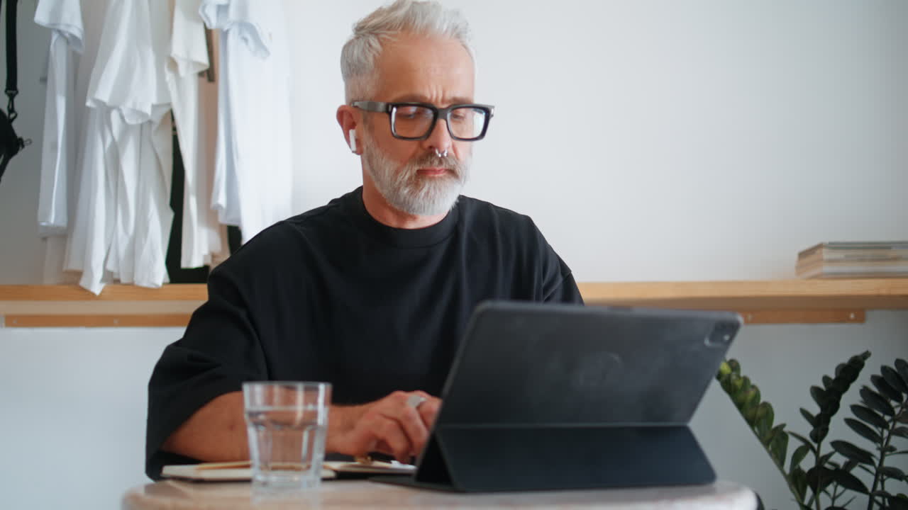 Stylish senior using tablet computer closeup. Thoughtful businessman browsing