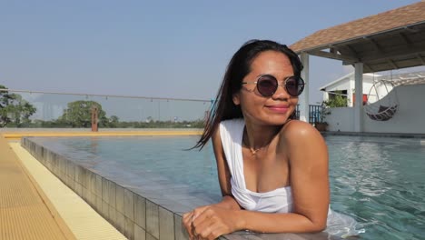 A-pretty-woman-in-white-swimsuit-relaxing-by-the-poolside-during-summertime-in-Pattaya-Hotel---Close-Up-Shot