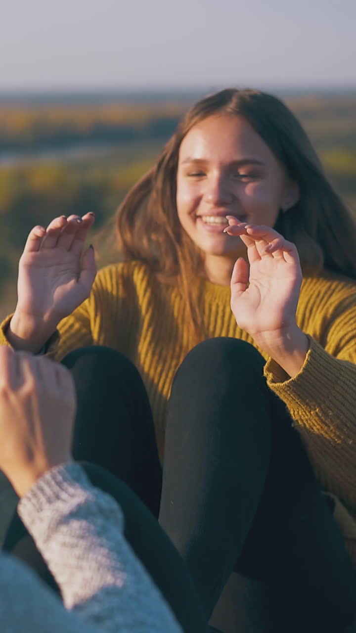 happy young women hikers do abs exercises on grass of steep river bank against pictorial nature in warm autumn evening