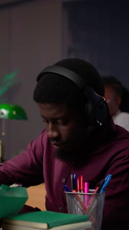 vertical video african american guy uses ambient focus music to help with school assignment