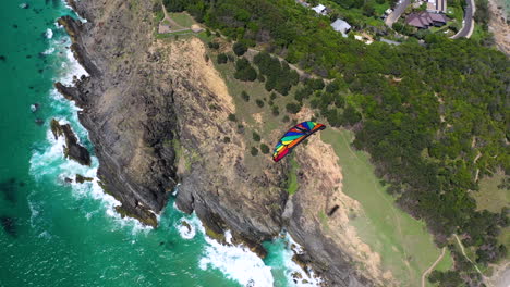 4k drone disparó sobre un parapente, volando sobre las montañas y la costa en byron bay, australia
