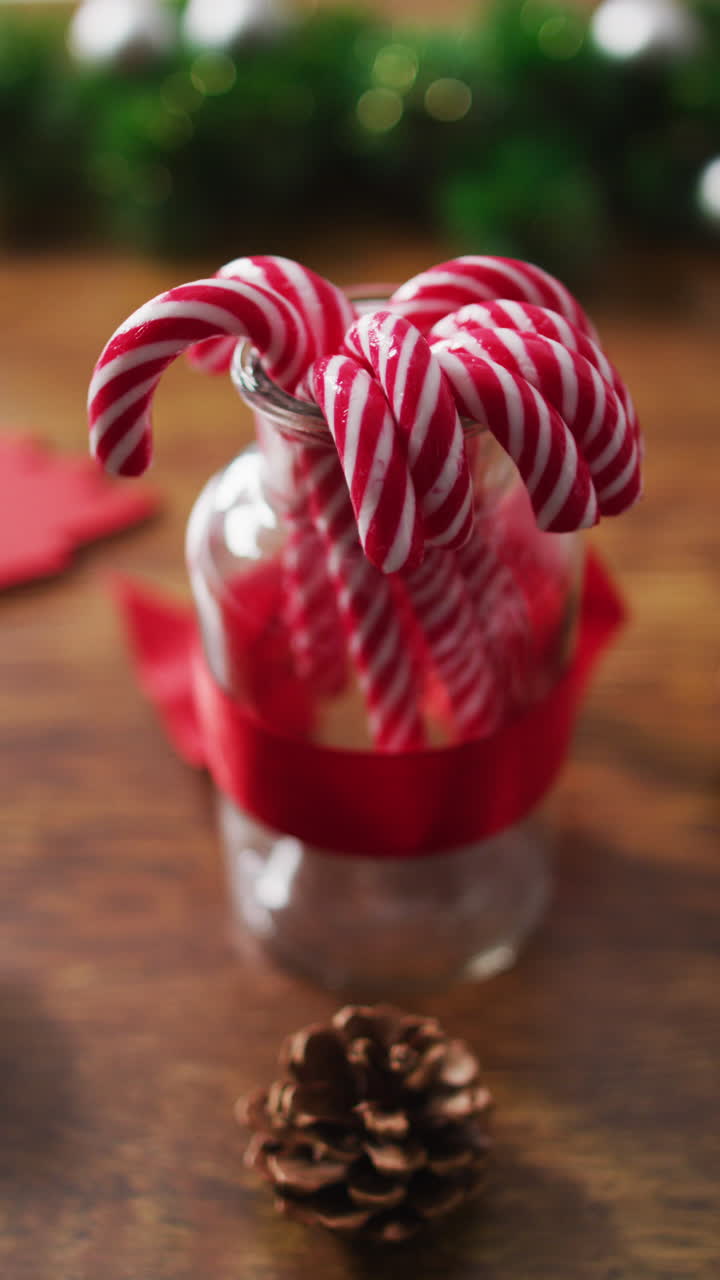 primer plano de cañas de caramelo en un frasco con decoraciones de navidad en una mesa de madera
