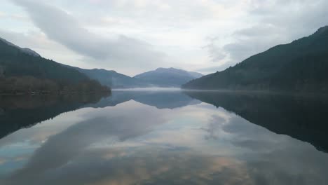 peaceful aerial of scottish loch with dramatic cloud reflections