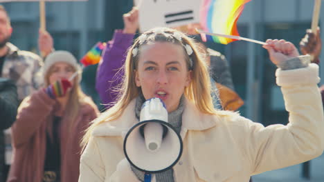 gruppe von demonstranten mit megafonen, die fahnen schwenken, auf einem demonstrationsmarsch für geschlechtergleichheit