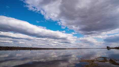 paisaje fluvial natural 4k hd alta definición reflejo acelerando en el nivel del agua de las nubes. reflejo de fondo de las nube en el agua ondulante. paisaje relajante escénico en un día claro de verano. bucle