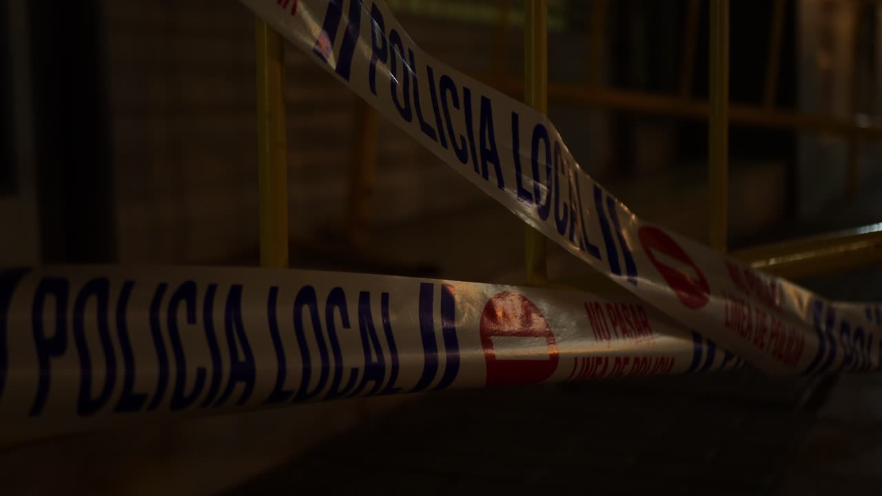 Local police tapes moving in the wind. Spanish text
