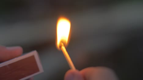 primer plano de un hombre que enciende un fósforo al anochecer en cámara lenta en francia ambiente oscuro y fuego