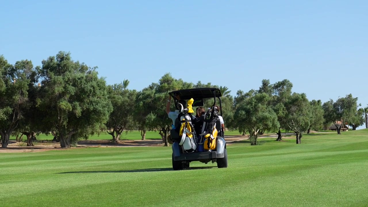 People Riding in a Golf Cart on a Sunny Golf Course