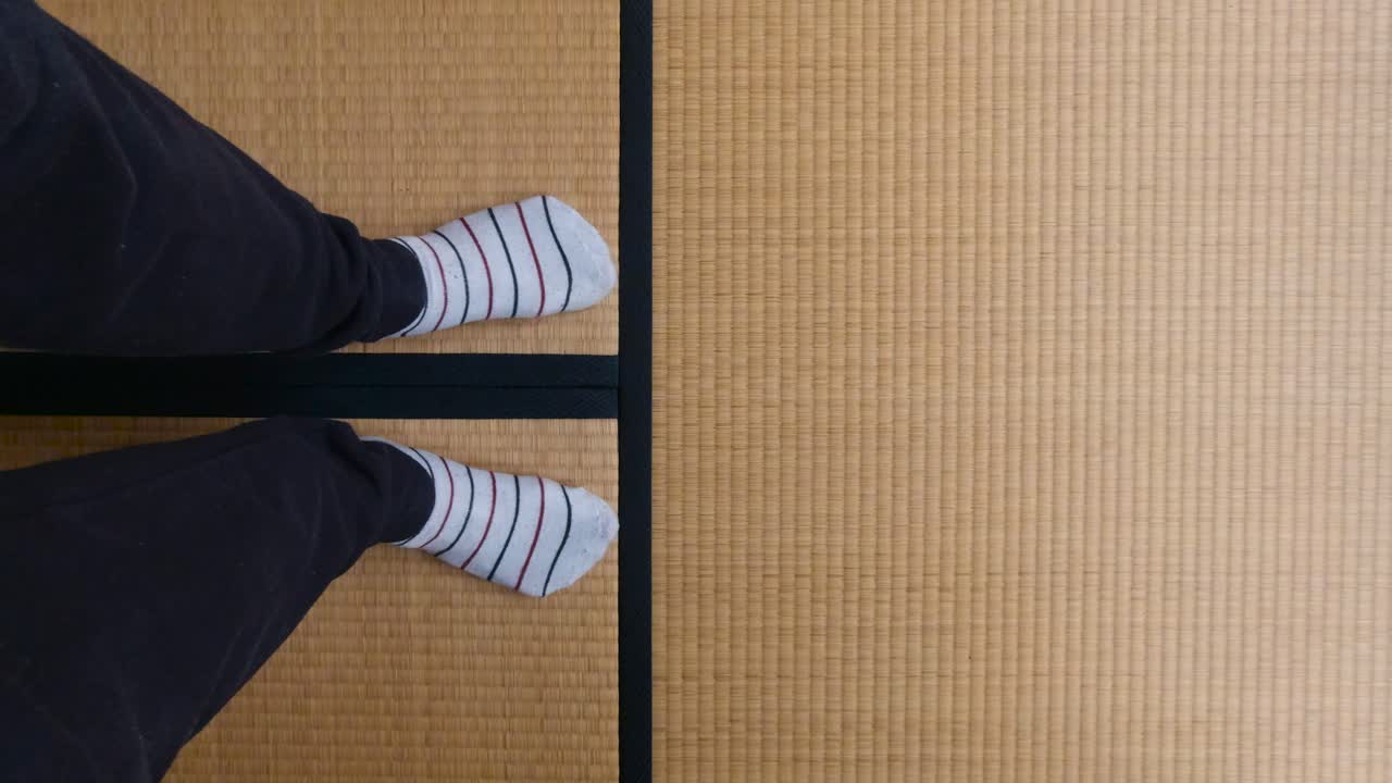 hombre vestido con ropa cómoda caminando en un tatami japonés - tiro medio
