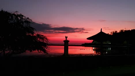 hermoso atardecer de cielo rosado reflejando sobre el océano tranquilo a lo largo de la costa en los trópicos de dili, timor-leste, sudeste asiático