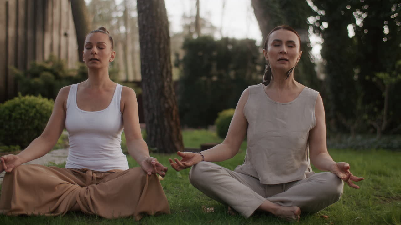 dos mujeres meditando al aire libre
