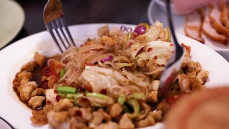 delicious spicy noodle salad being prepared and served