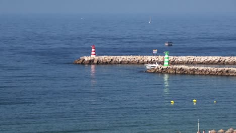 Villamoura-harbour-entrance-in-the-Agarve-Portugal-with-boats-and-and-light-houses-on-a-calm-sunny-morning