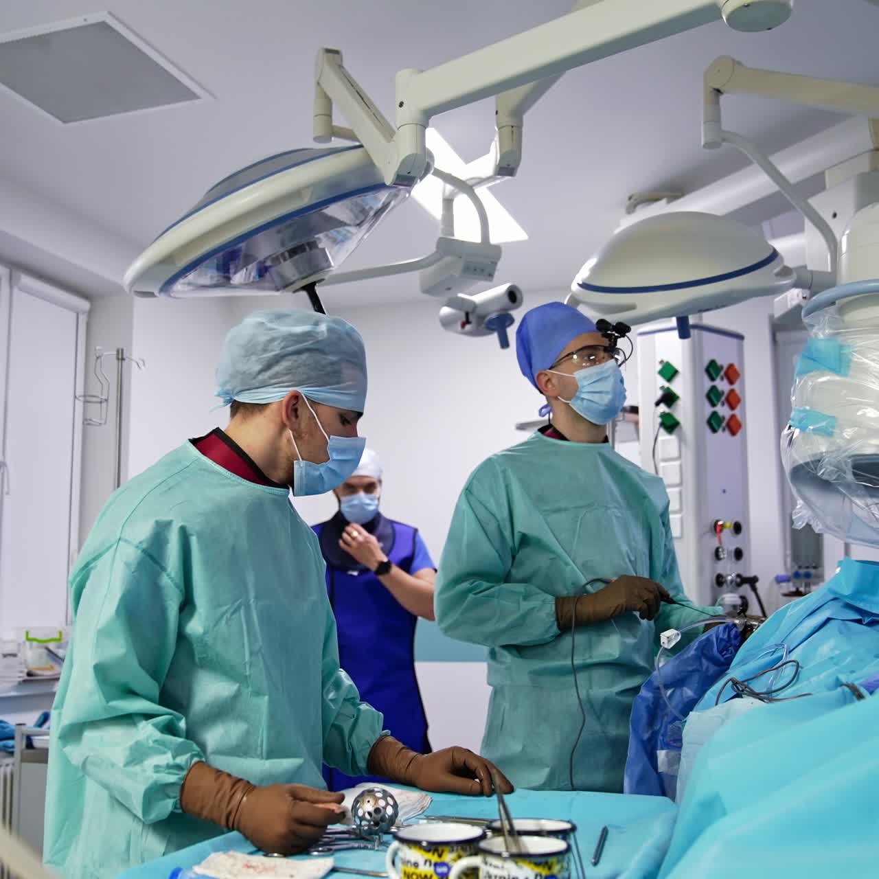 Neurosurgical operation conducted in well-equipped surgery room. Male team of professional surgeons performing operation
