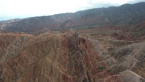 aerial pan across stunning landscape of fairytale canyon skazka, kyrgyzstan, showcasing the canyon's layered rock formations and rugged beauty