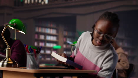 vertical video african american student comparing class notes with data from the library