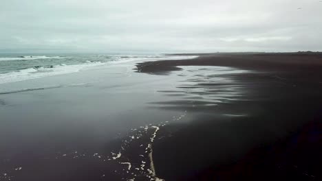 haunting beautiful aerial over a black sand beach in southern iceland 4
