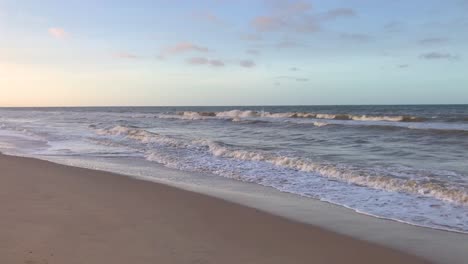 waves on a sandy caribbean sea beach during sunset with a beautiful sky