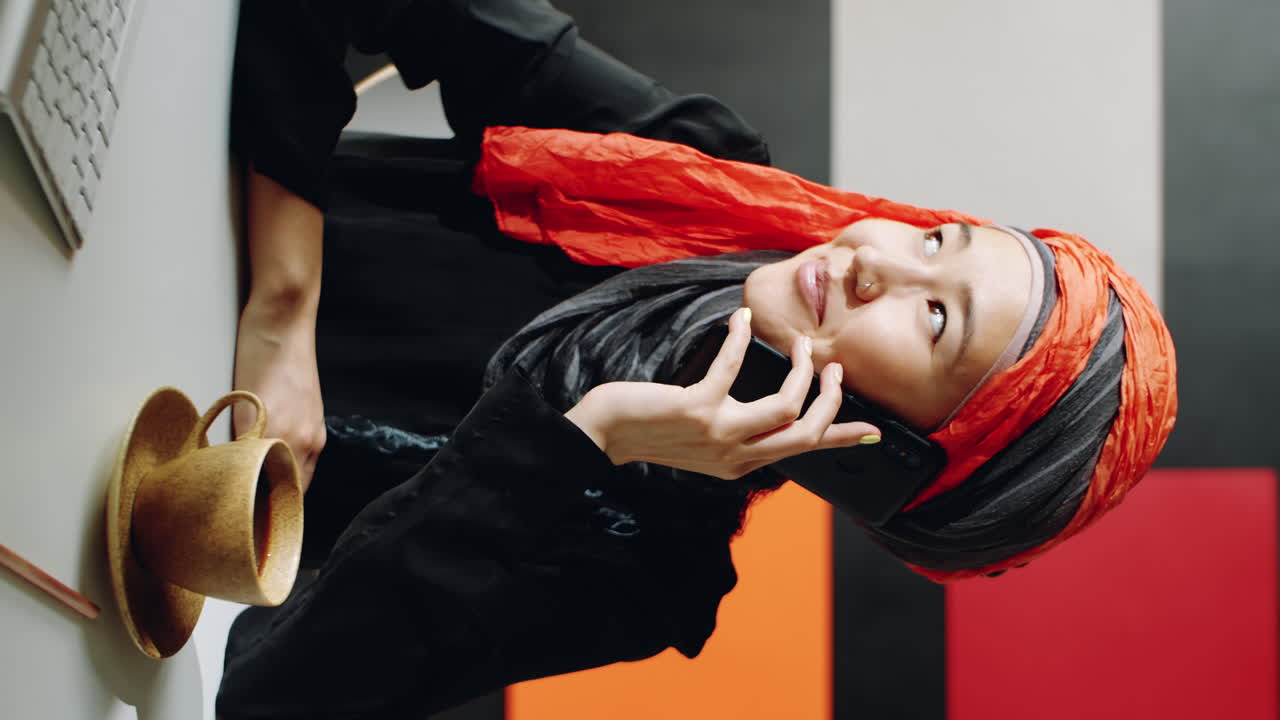 무슬림 여성이 전화로 말하고 있습니다.