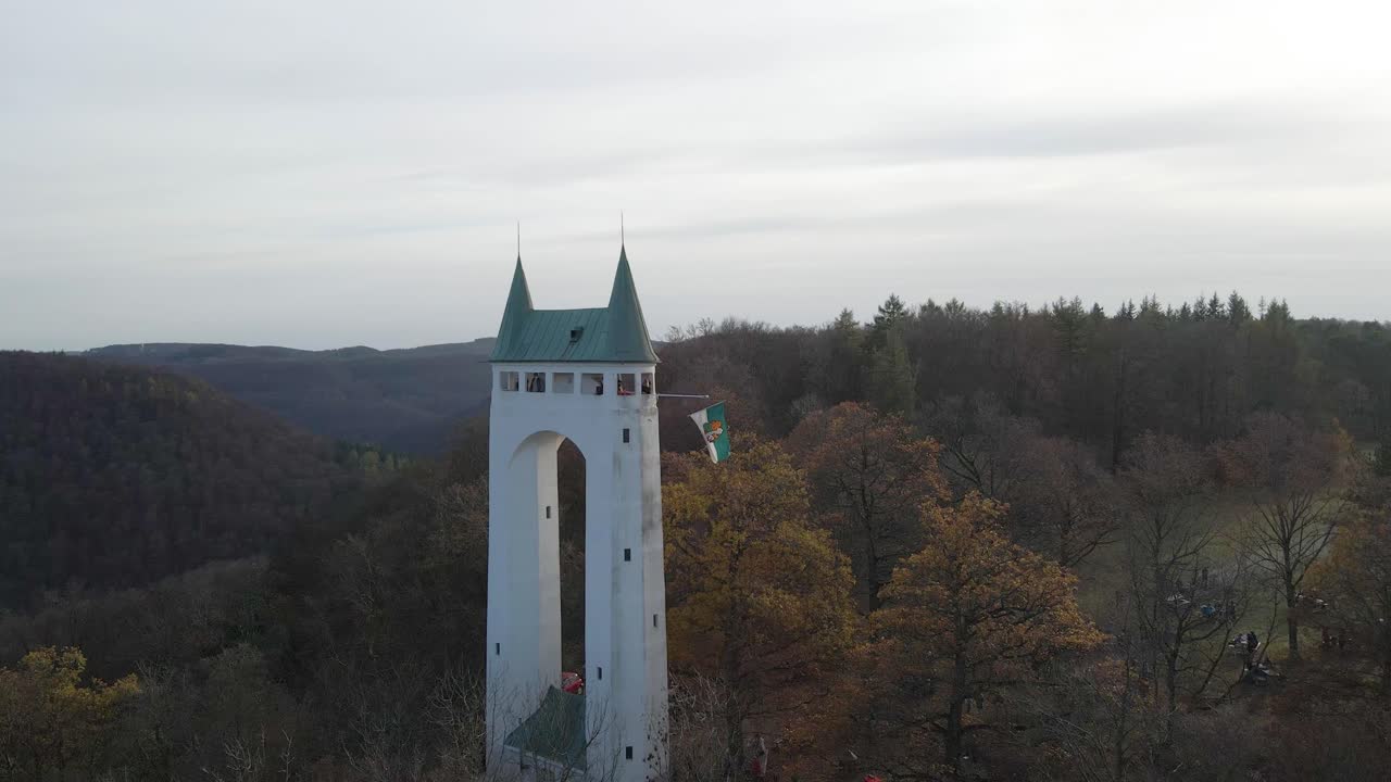 Aerial view of an old tower in the Swabian Alb with a flag waving in Slow Motion