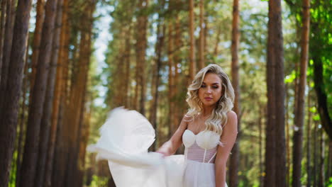 Pretty-bride-waves-skirt-holding-flowers-bouquet-in-park