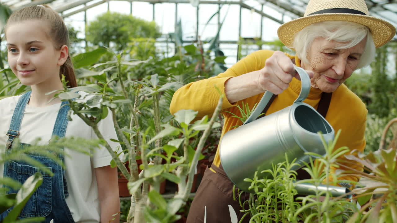 Grandmother and Granddaughter Gardening in a Greenhouse