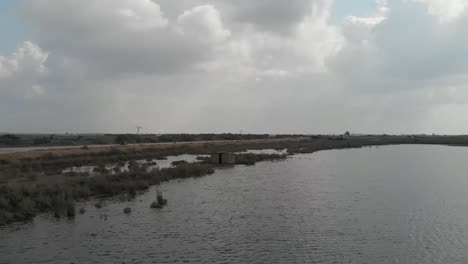 Antena-Sobre-Un-Lago-Rural-Al-Lado-De-La-Carretera-En-Sindh,-Pakistán