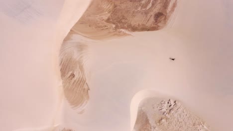 kitesurfer with a yellow kite walk on a sanddune birdseye perspective