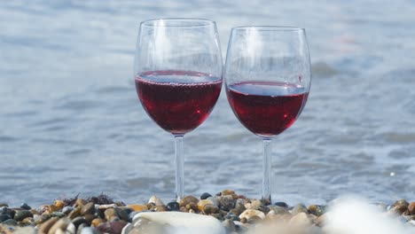 dos vasos de vino tinto en la playa