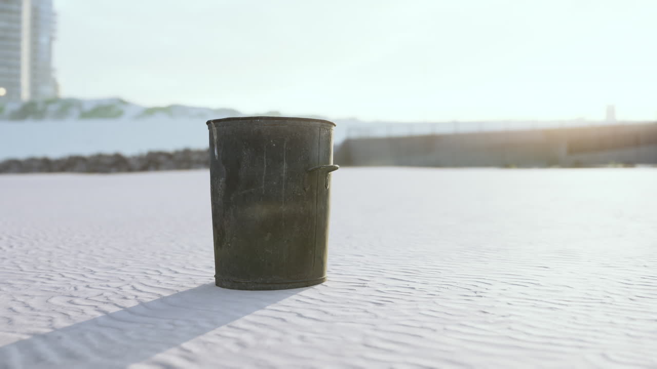 Gray metal garbage bin or trash can on the beach