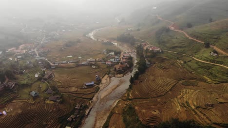 cinematic aerial drone footage of rice terraces and farm work in north region of sapa vietnam with sun shining through clouds after long day of rainfall