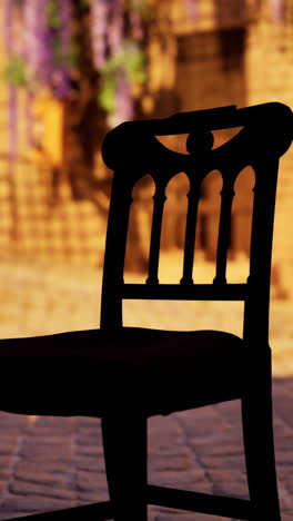 a silhouette of a vintage wooden chair in a garden