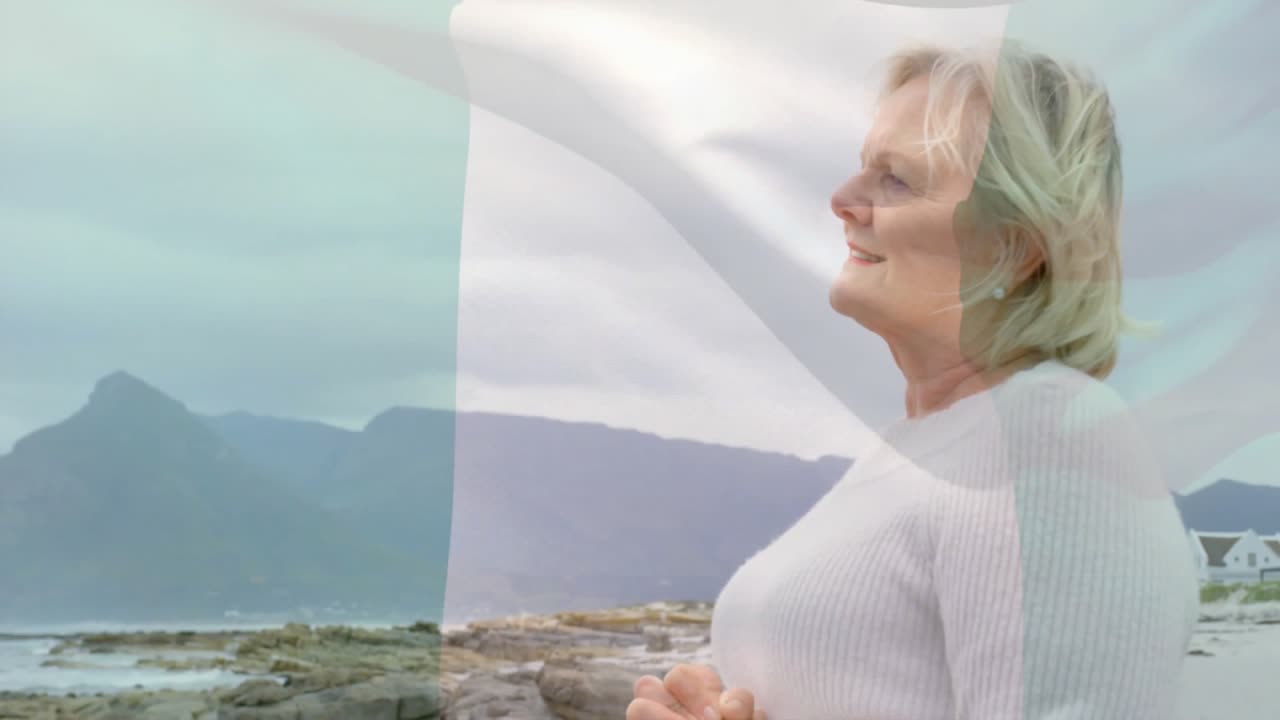 Donna anziana in piedi su una costa rocciosa, con un grafico finanziario animato che fluttua sopra l'orizzonte