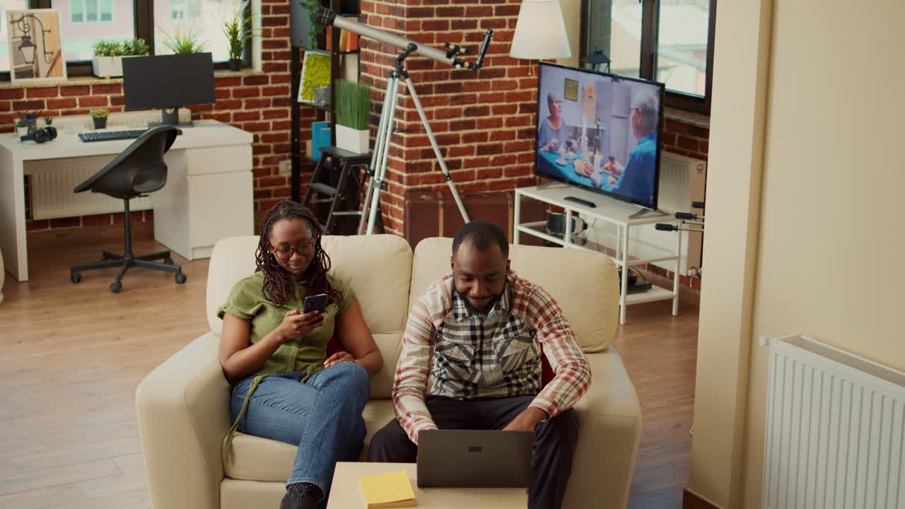 African american modern couple relaxing at home on couch