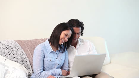pareja escribiendo en una computadora portátil