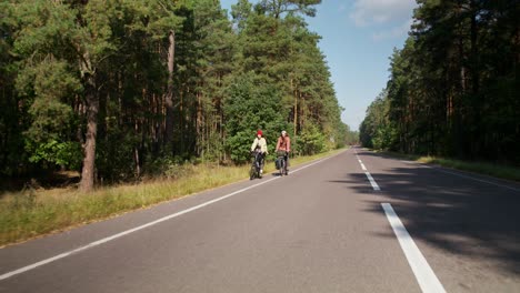 couple cycling through a forest