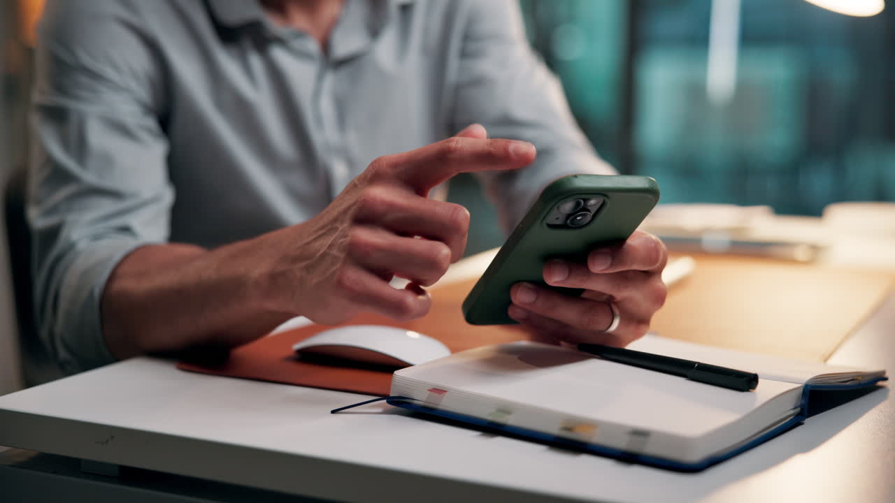 Close-Up of Person's Hands Using a Smartphone at a Desk